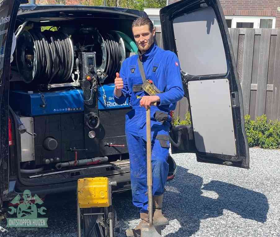Een tevreden monteur met opgestoken duim naast de bestelbus, slim ingrijpen bespaart kosten bij een verstopte afvoer in Huizen