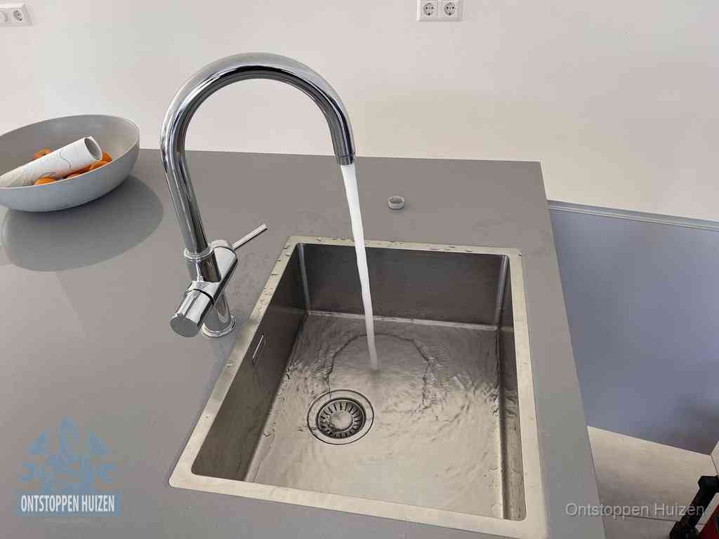 Een vrij doorstromende rvs spoelbak waar het water moeiteloos wegloopt, het resultaat van slim onderhoud dat geld bespaart in Huizen