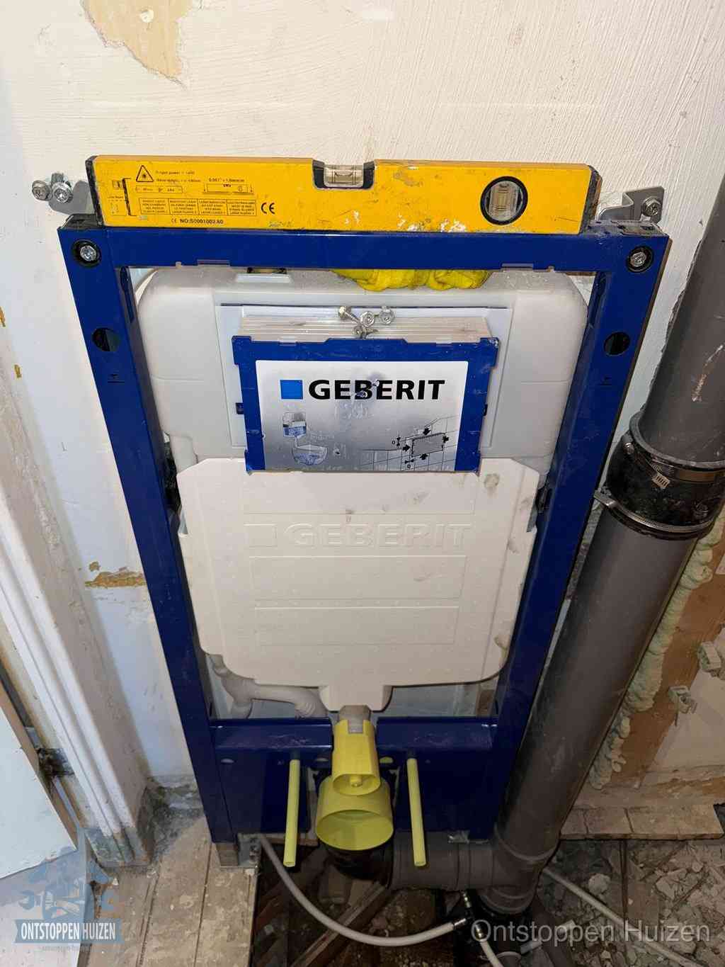 Een Geberit inbouwreservoir met frame voor een hangtoilet tegen de wand, met de afvoerbocht naar de vloer, kenmerkend voor een verstopt hangtoilet in Huizen