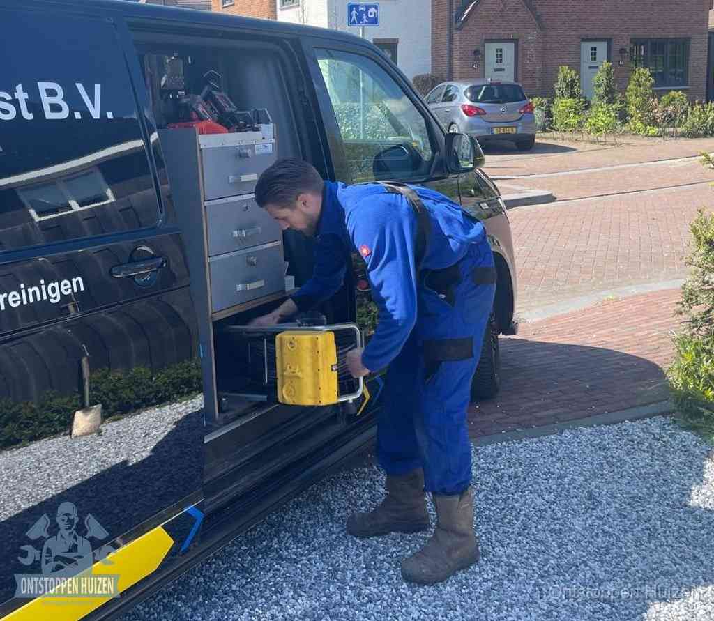 Een monteur pakt apparatuur uit de bedrijfsbus voor service aan huis, het moment om een professional in te schakelen in Huizen