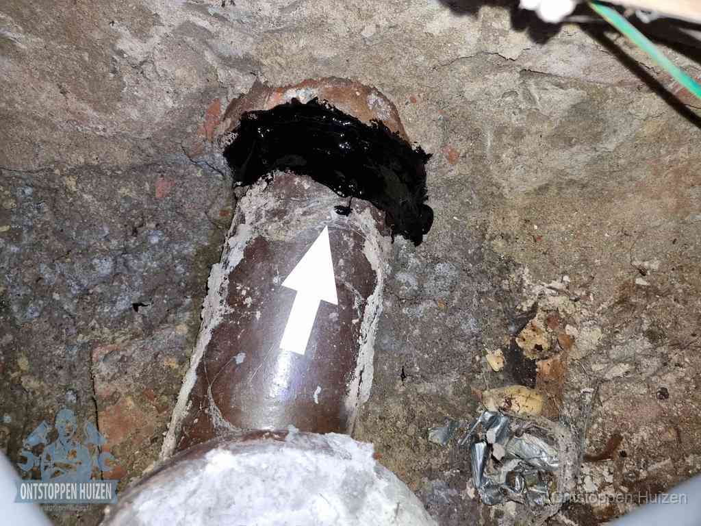 Een oude gres rioolbuis met een beschadigde koppeling onder de vloer, oorzaak van terugkerende structurele wc-problemen in Huizen