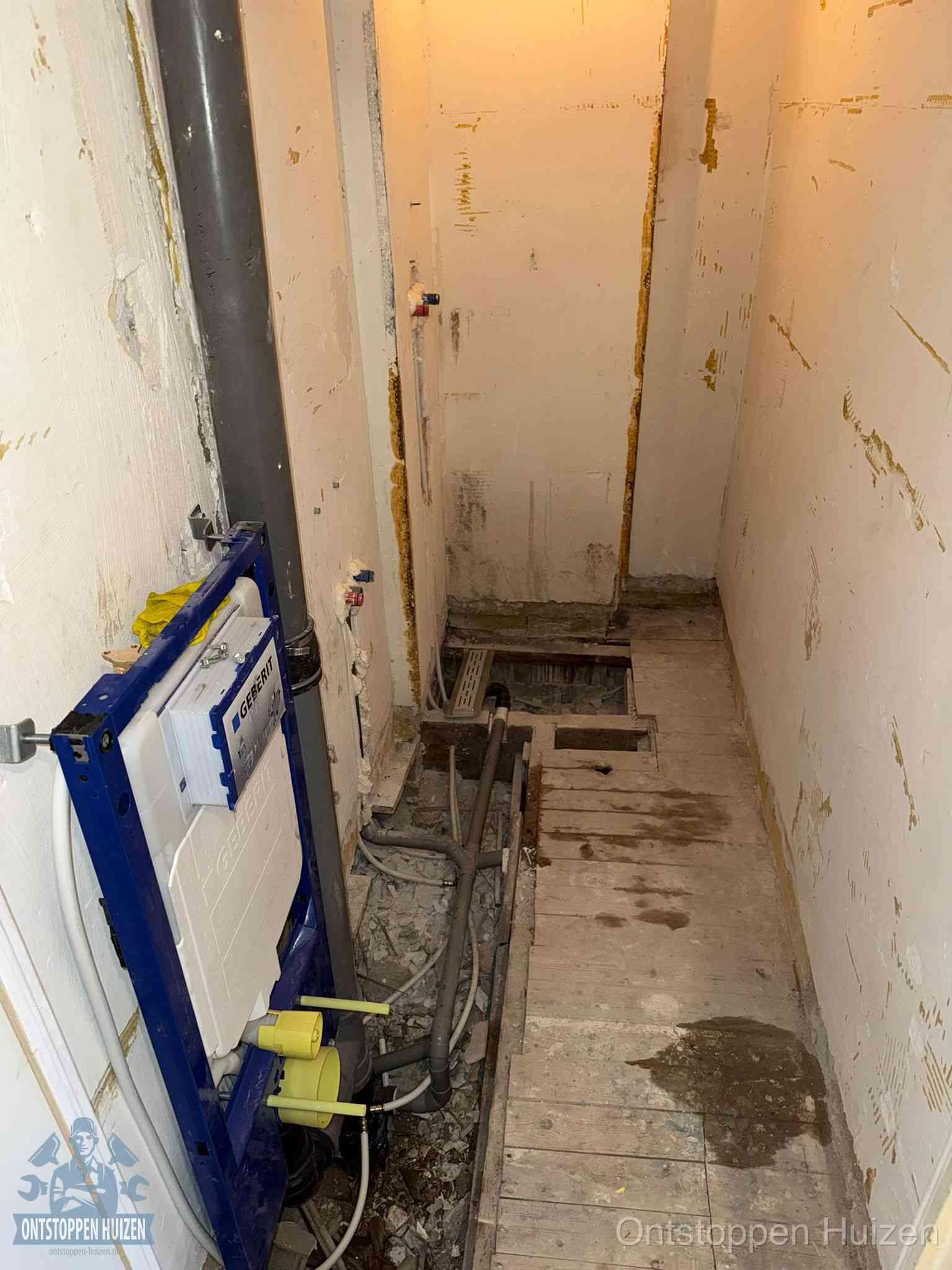 Een opgebroken toiletruimte tijdens renovatie met een Geberit inbouwreservoir en blootliggende oude afvoerleidingen, typisch voor oudere woningen in Huizen